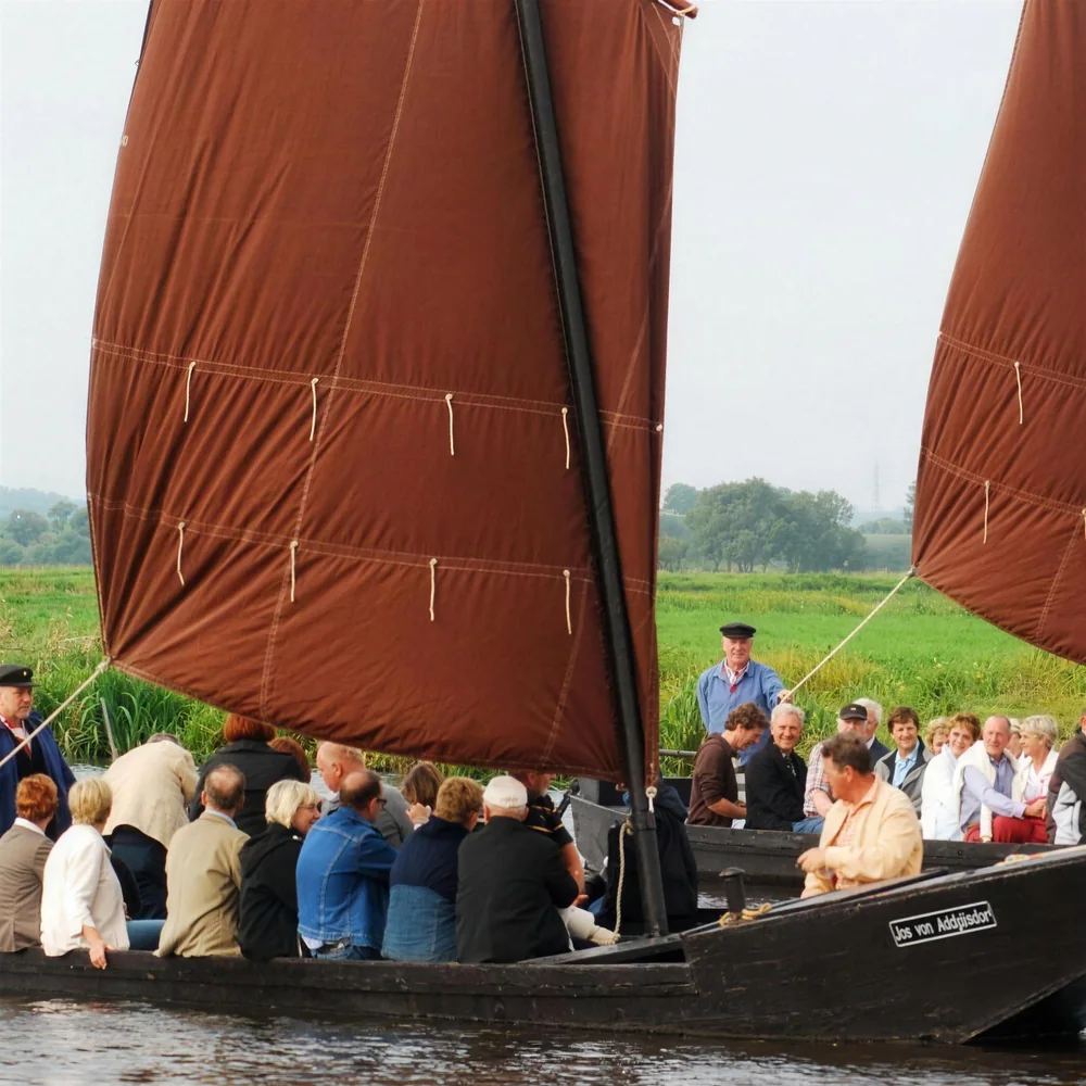 Torfkähne mit braunen Segeln und Gästen im Teufelsmoor
